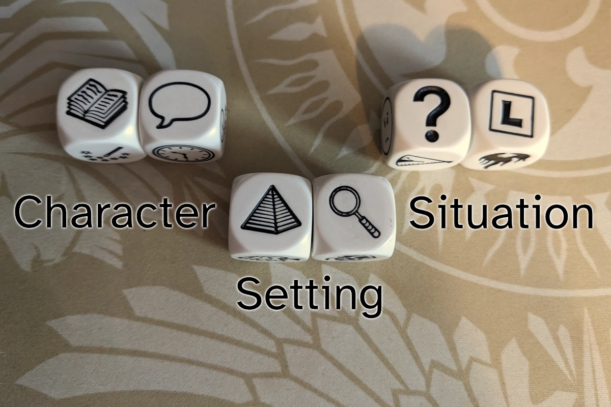 Three pairs of Rory's Story Cubes showing a book & a speech bubble, a pyramid & a magnifying glass, and a question mark & a square with a capital letter L in it. They're labeled "Character," "Setting," and "Situation."